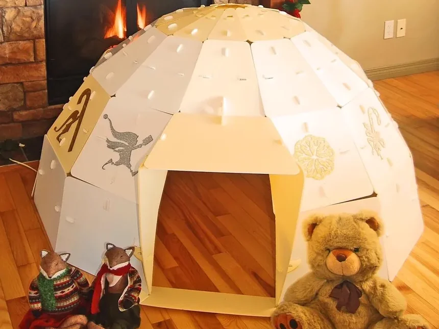 A gold NimoPlay igloo playhouse glowing in a cozy corner of a living room by the fireplace