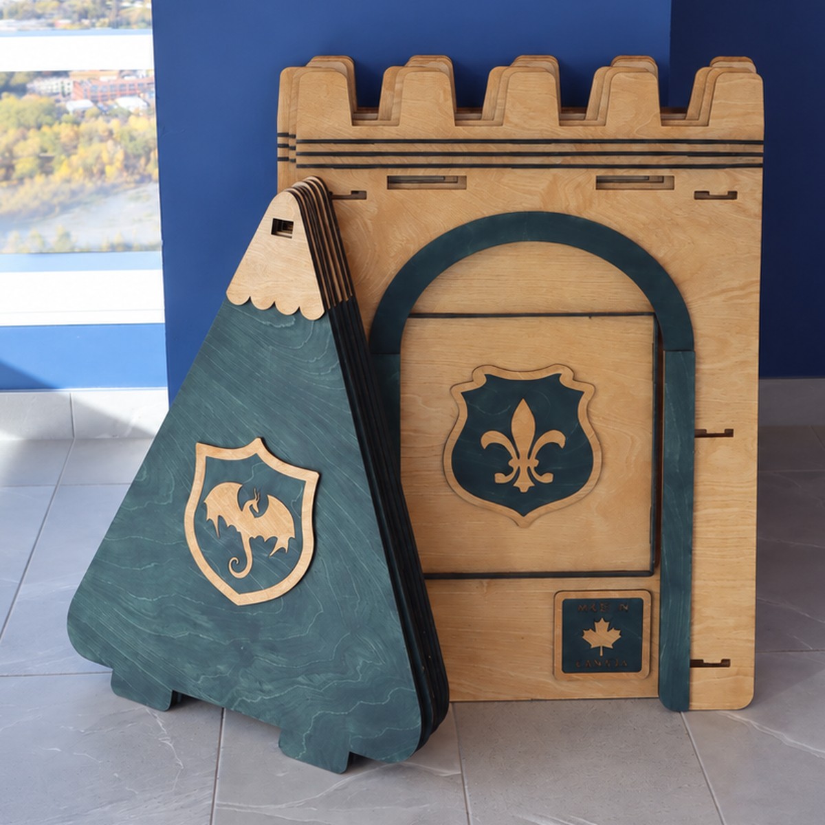 A green NimoPlay castle playhouse packed flat and leaning against a wall